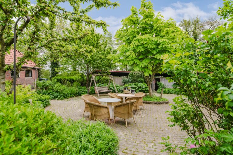 Terras met tuinstoelen in de tuin van De Ripen