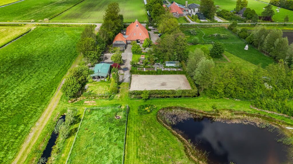 Luchtfoto van De Ripen 16 met boerderij, tuin en poel